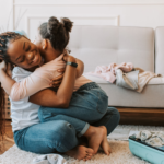 Mother hugging her young daughter in a safe home, representing hope, recovery, and family reunification