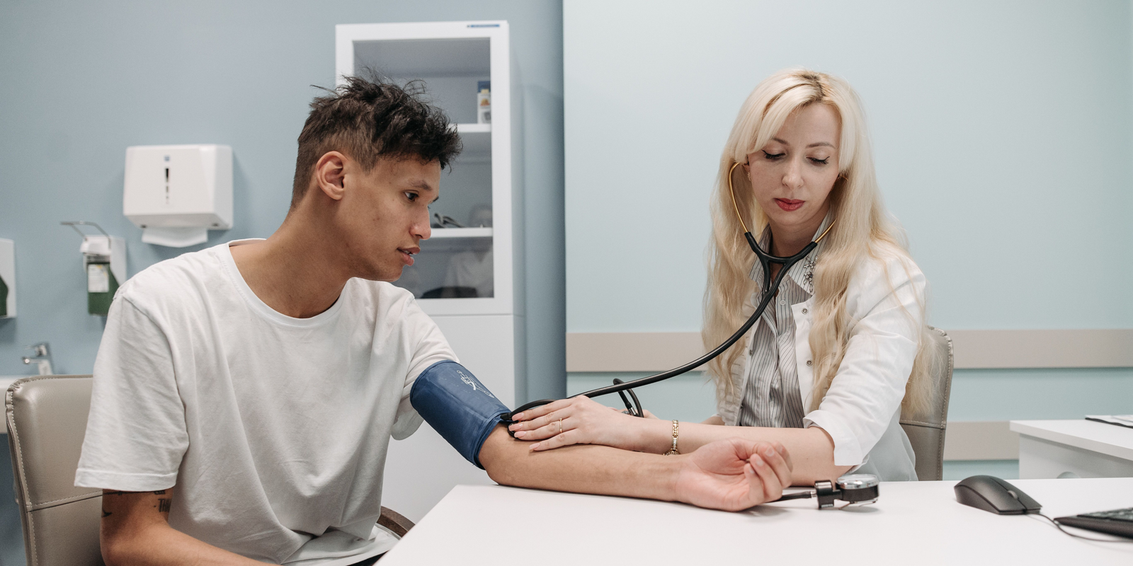 A healthcare professional checks a patient's blood pressure during a medical appointment.